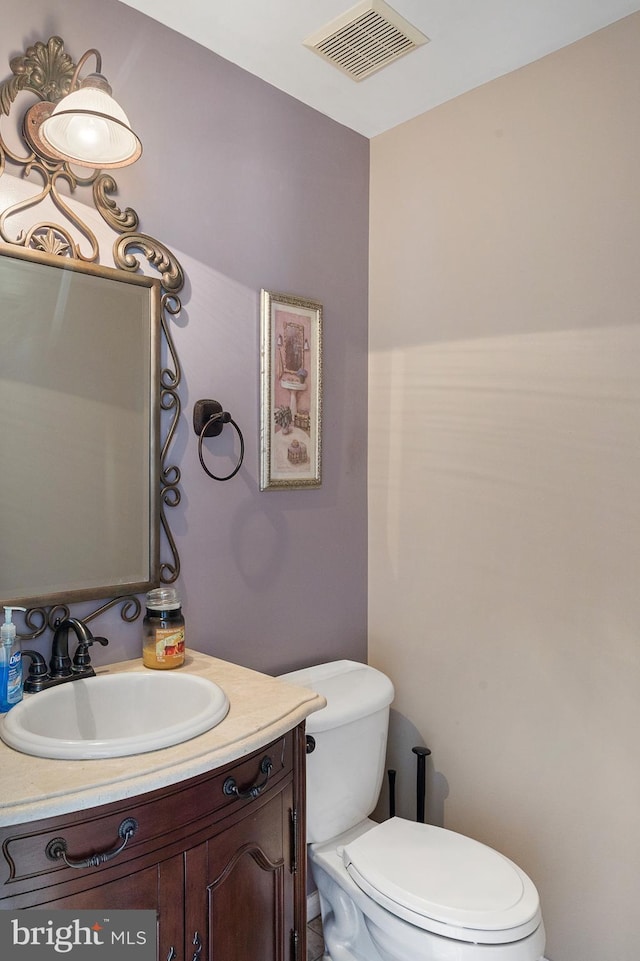 bathroom featuring toilet, visible vents, and vanity