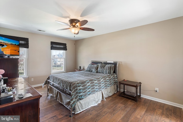 bedroom with dark wood-style floors, ceiling fan, visible vents, and baseboards