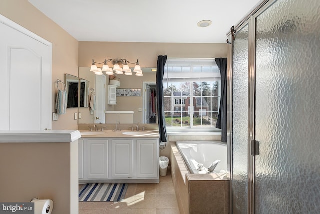 bathroom with a garden tub, a sink, a shower stall, tile patterned floors, and double vanity