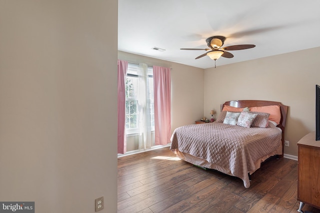 bedroom with dark wood-style floors, ceiling fan, visible vents, and baseboards