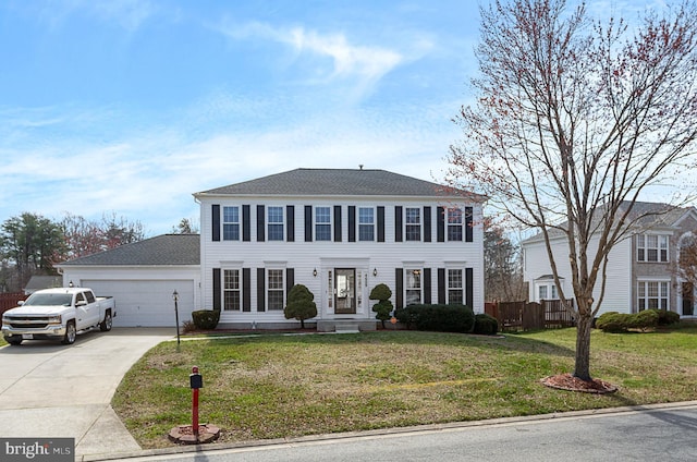 colonial house featuring a garage, concrete driveway, and a front yard