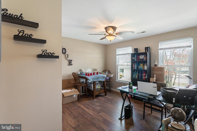 office space with baseboards, dark wood-type flooring, visible vents, and a ceiling fan