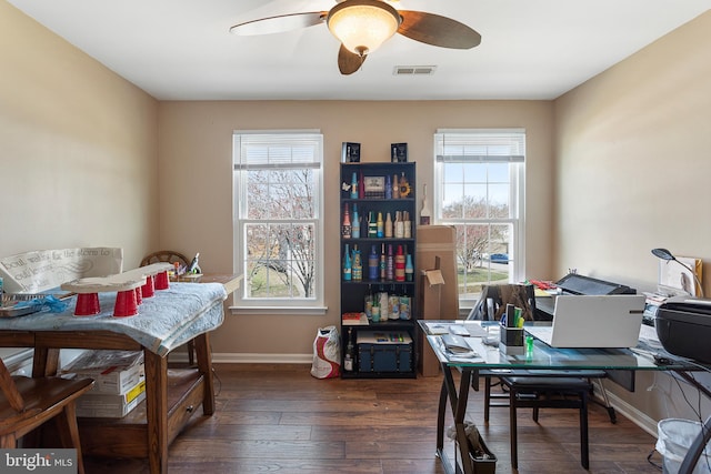 office space with ceiling fan, plenty of natural light, visible vents, and dark wood finished floors