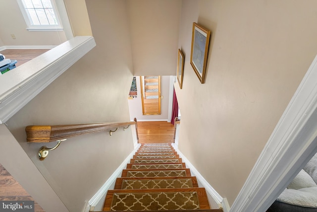 stairs with wood finished floors and baseboards