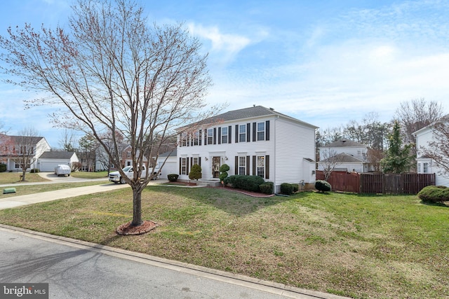 colonial home featuring fence and a front lawn