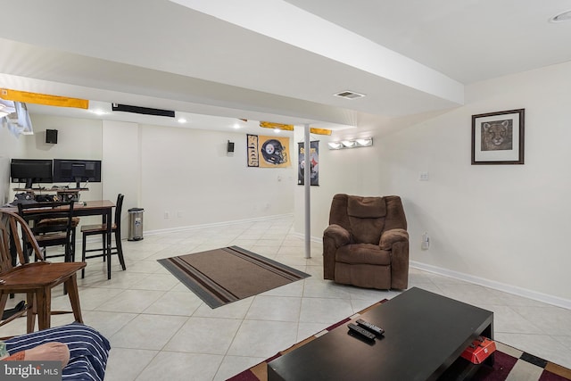 living area with light tile patterned floors, visible vents, and baseboards