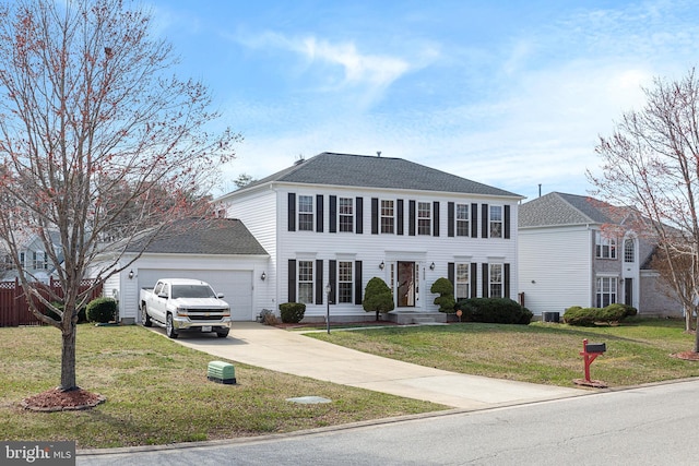 colonial house featuring a garage, concrete driveway, a front lawn, and roof with shingles