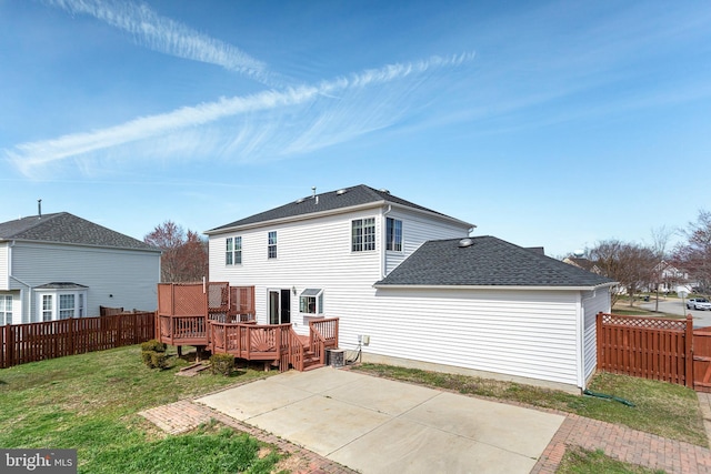 rear view of house featuring a fenced backyard, a deck, a yard, a patio area, and central AC