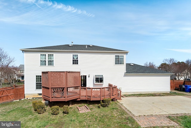 rear view of house featuring a patio area, a wooden deck, fence, and a yard