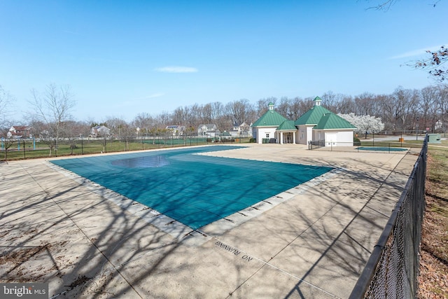 community pool featuring fence and a patio