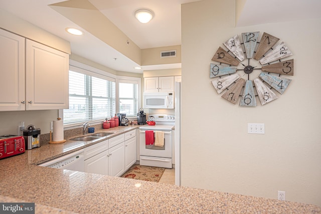 kitchen featuring sink, white appliances, and white cabinetry