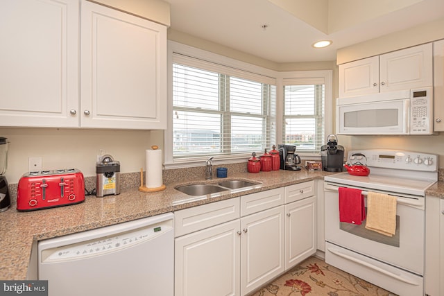 kitchen featuring white appliances, white cabinetry, and sink