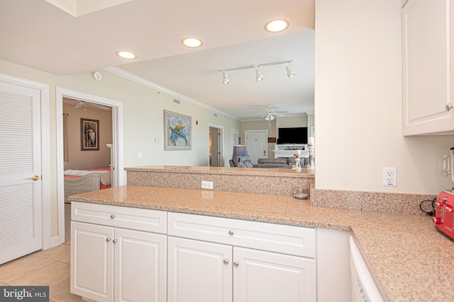 kitchen featuring light stone countertops, light tile patterned floors, ornamental molding, ceiling fan, and white cabinets