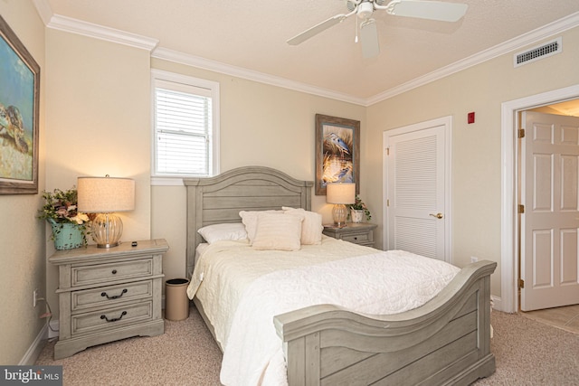 carpeted bedroom with a closet, ceiling fan, and ornamental molding