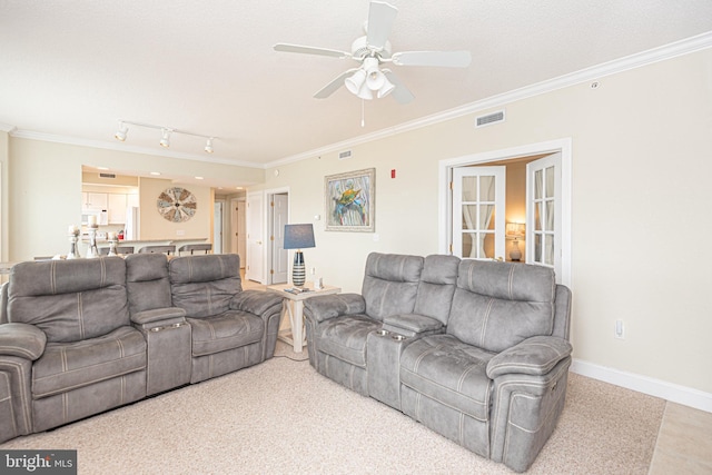 carpeted living room with track lighting, ceiling fan, and ornamental molding