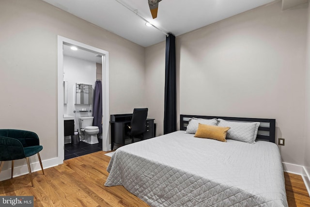 bedroom featuring hardwood / wood-style flooring, ensuite bath, and ceiling fan