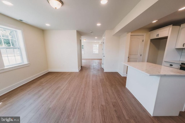 kitchen with white cabinetry, light hardwood / wood-style floors, and a kitchen island