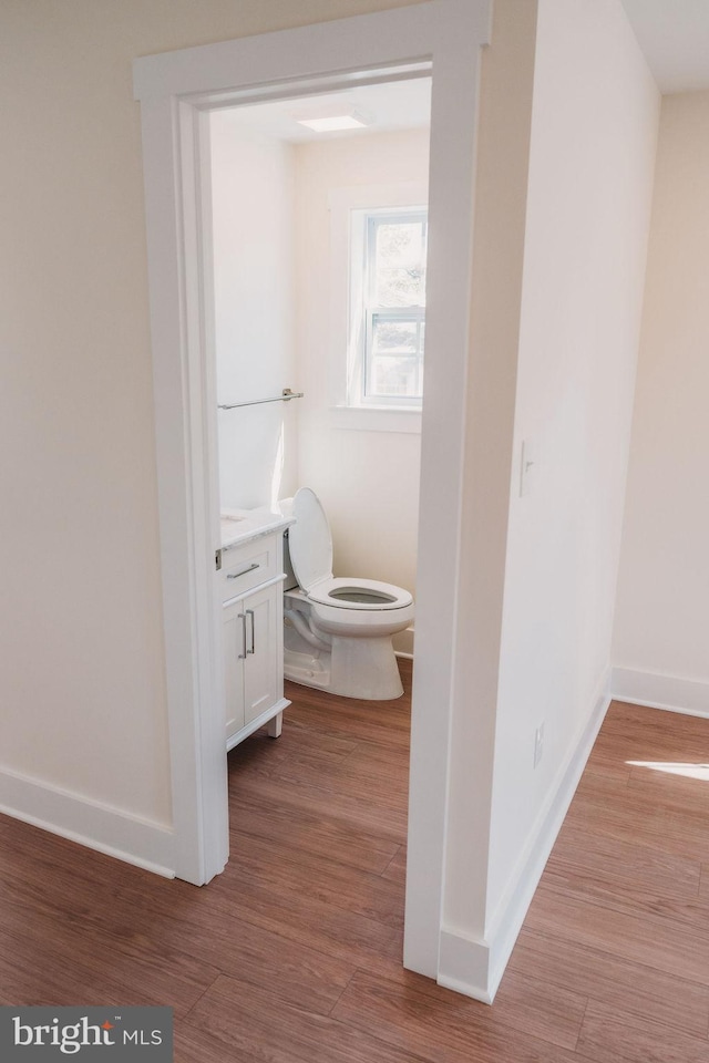 bathroom featuring hardwood / wood-style flooring, vanity, and toilet