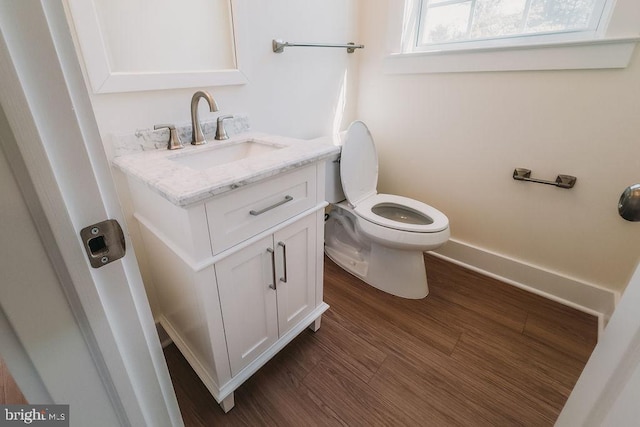 bathroom with hardwood / wood-style flooring, vanity, and toilet