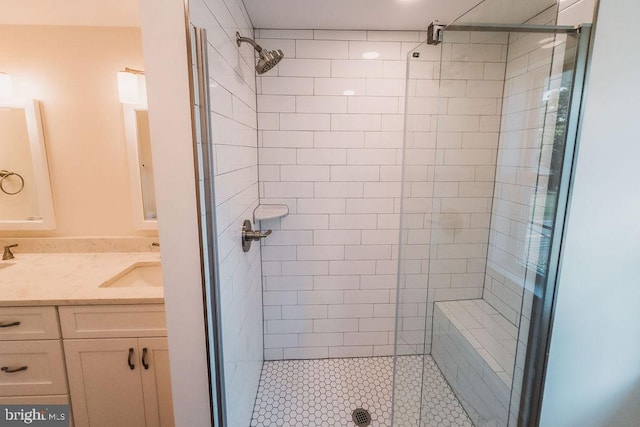 bathroom with a shower with shower door and vanity