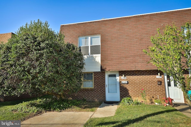 view of front of home with a front yard and brick siding