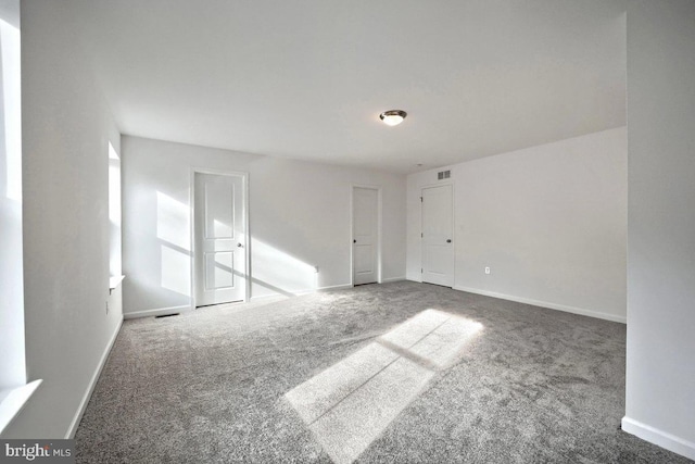 unfurnished room featuring visible vents, baseboards, and carpet floors