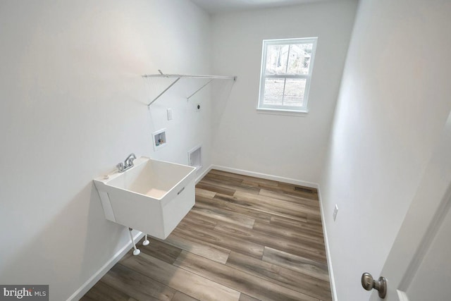 clothes washing area with wood finished floors, baseboards, hookup for an electric dryer, hookup for a washing machine, and laundry area