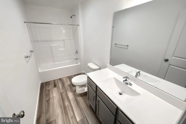 bathroom with vanity, toilet, wood finished floors, and tub / shower combination