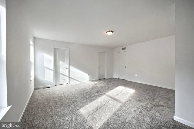 carpeted empty room with baseboards and visible vents