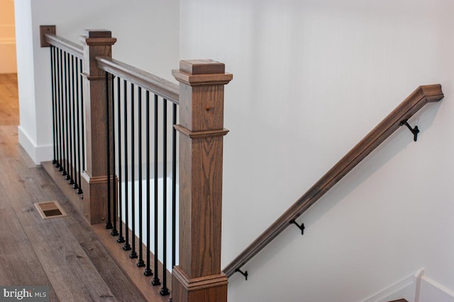 stairs featuring visible vents, baseboards, and wood finished floors