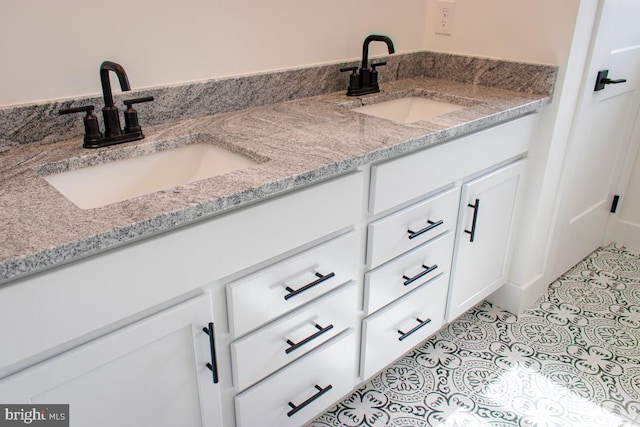 bathroom featuring tile patterned flooring, double vanity, and a sink