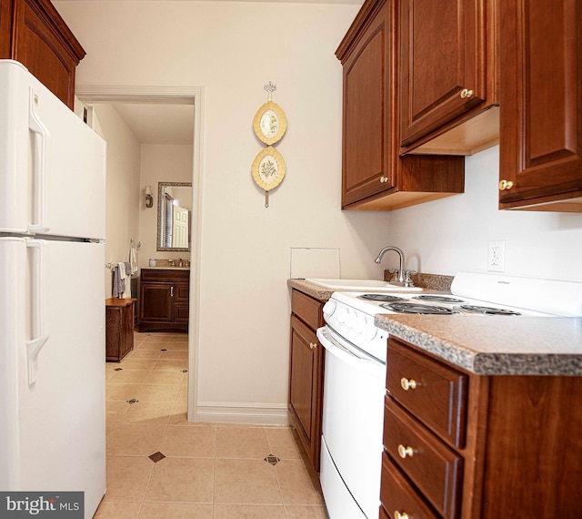 kitchen featuring white appliances, light tile patterned floors, and sink