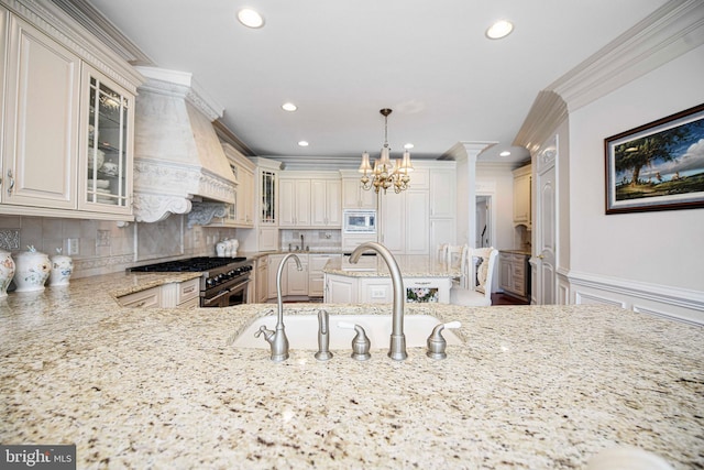 kitchen featuring pendant lighting, tasteful backsplash, sink, appliances with stainless steel finishes, and light stone countertops