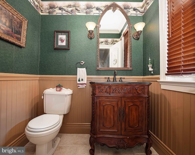 bathroom with tile patterned flooring, wood walls, vanity, and toilet