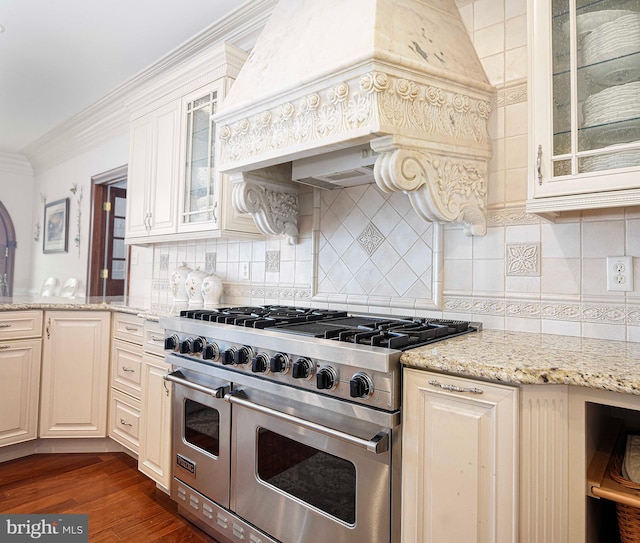 kitchen with tasteful backsplash, light stone countertops, custom exhaust hood, double oven range, and dark hardwood / wood-style floors