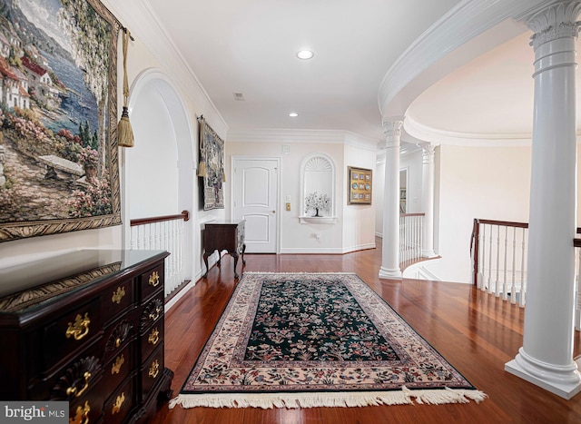 entrance foyer with decorative columns, crown molding, and dark hardwood / wood-style flooring