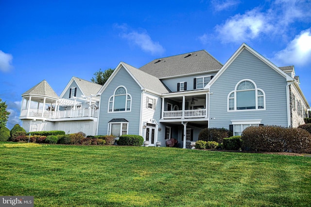 view of front of property featuring a balcony and a front yard