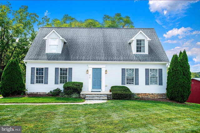 cape cod-style house featuring a storage shed and a front yard