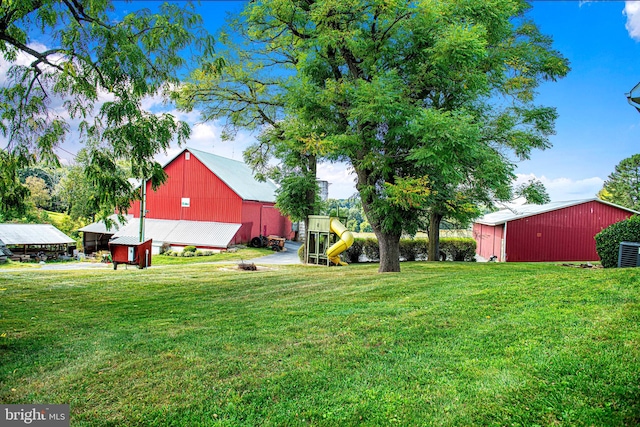 view of yard featuring a playground and an outbuilding