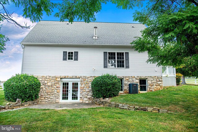 rear view of property with central AC, french doors, and a yard