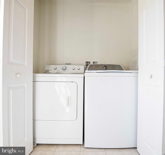 laundry room with light tile patterned floors and washing machine and dryer