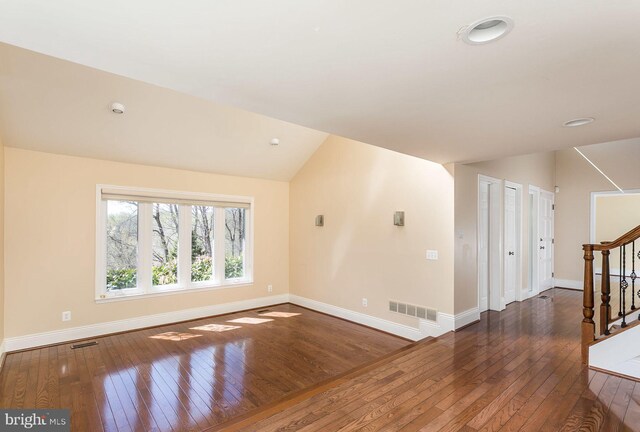 unfurnished room with dark hardwood / wood-style flooring and lofted ceiling