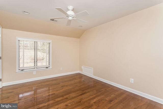 spare room with ceiling fan, vaulted ceiling, and wood-type flooring