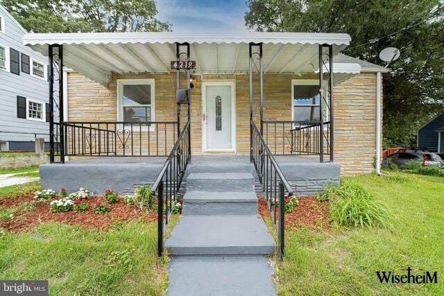 view of front of house featuring covered porch and a front lawn