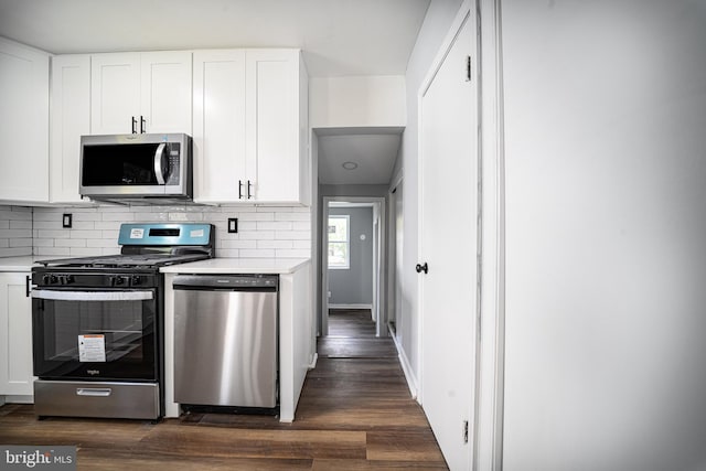 kitchen with dark hardwood / wood-style floors, white cabinets, and stainless steel appliances