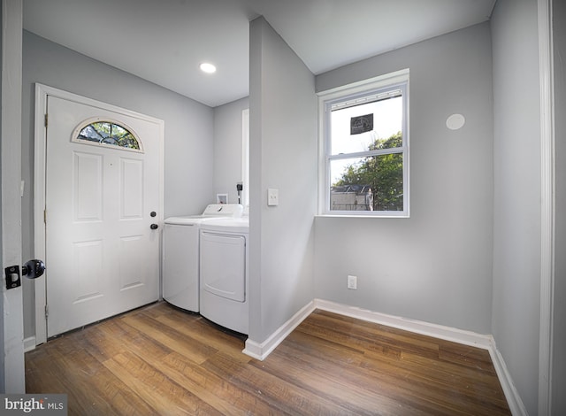 washroom with washing machine and clothes dryer and hardwood / wood-style floors