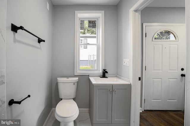 bathroom with hardwood / wood-style flooring, vanity, and toilet