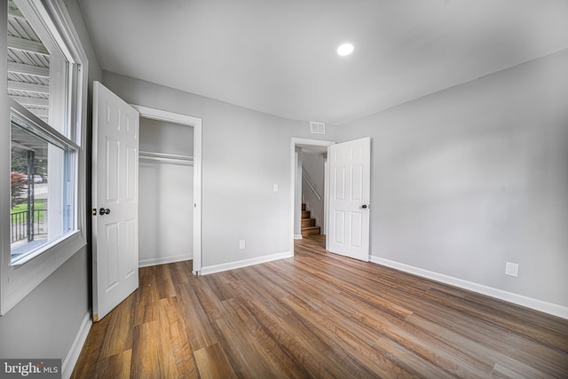 unfurnished bedroom with a closet and hardwood / wood-style flooring