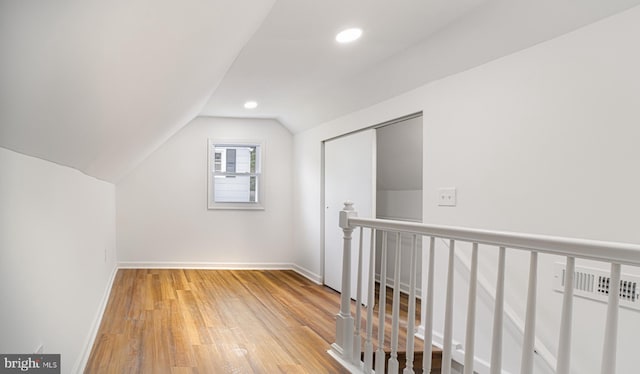 bonus room with hardwood / wood-style floors and lofted ceiling