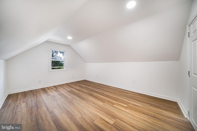 additional living space with lofted ceiling and light hardwood / wood-style floors